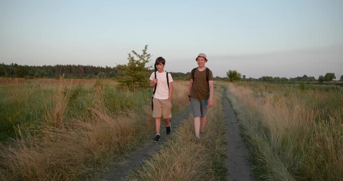 Two friends boys hike walking on nature. Teenagers spending time together. 4K 10-bit