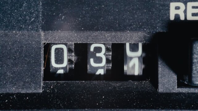 Vintage analog tape deck counter mechanism with three digits spinning during playback. Macro shot