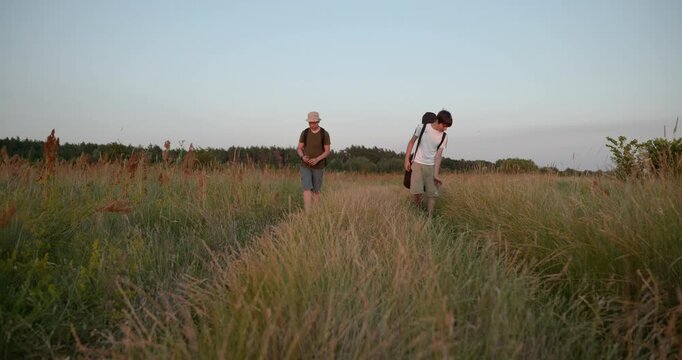 Two friends boys hike walking on nature. Teenagers spending time together. 4K 10-bit