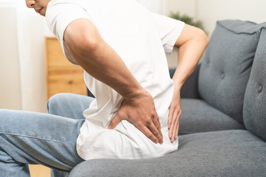 Pain body muscles stiff problem, asian young man, male standing painful with back ache from work hand holding massaging rubbing shoulder hurt, sore at home. Health care and medicine concept.