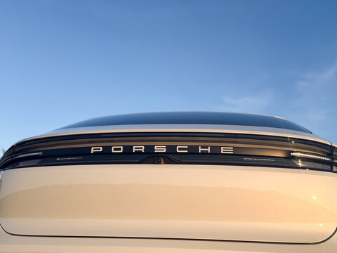 Close up of the rear of a porsche car with logo and taillight against a blue sky at sunset porsche macan 4 electric Poland, Pszczyna, 3.08.2026
