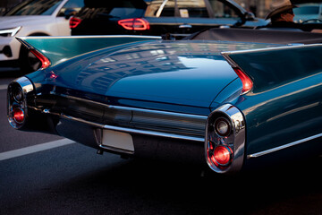 Rear view of vintage blue convertible classic car with tail fins on city street © Danny Aleja