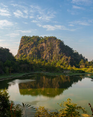 Fototapeta premium Forested Karst Mountain Reflected in Calm Lake