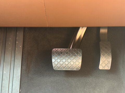 Close up of car pedals in the footwell with textured metal surfaces and floor mat, showing the driver area inside a vehicle. porsche cayenne gts Poland, Pszczyna, 3.08.2026 
