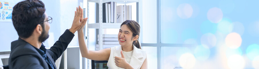 Businessman and businesswoman giving hi five or touching hands and thumb up at modern office. business union and success concept. © bigy9950
