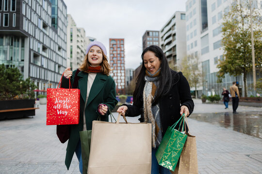 Women friends enjoying christmas shopping in city
