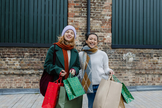 Women friends enjoying Christmas shopping with gift bags