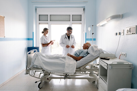 Healthcare professionals caring for a senior patient in hospital ward