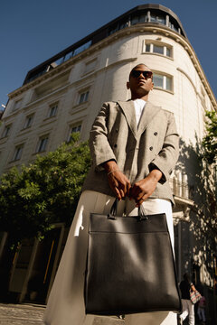 Man holding leather briefcase in low angle street editorial