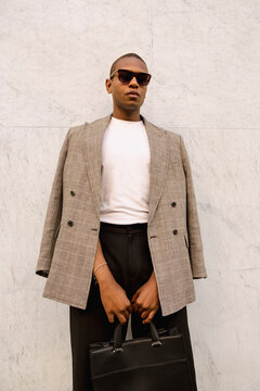 Man holding leather briefcase in formal street editorial portrait