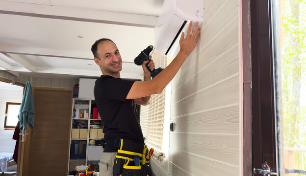 HVAC technician servicing an indoor air conditioner unit mounted on a wall, concept for maintenance service, home repair and technical support 