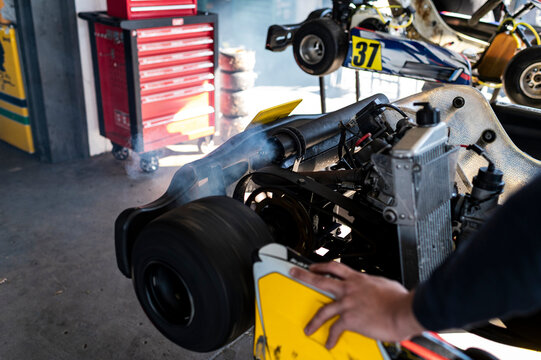 Close-up of a kart engine with exhaust smoke in the pit