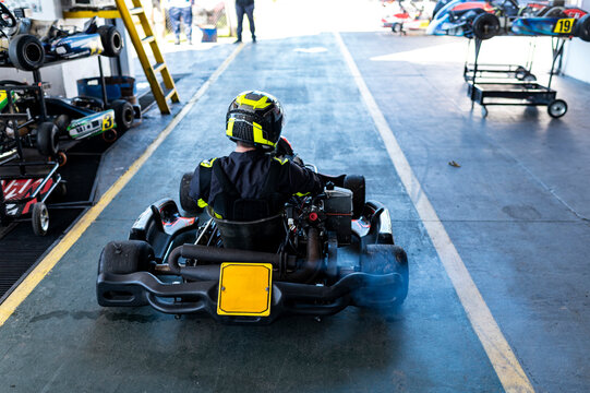 Kart racer heading down pit lane toward the track