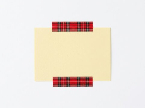 Blank rectangular paper note attached with red plaid patterned washi tape isolated on white background