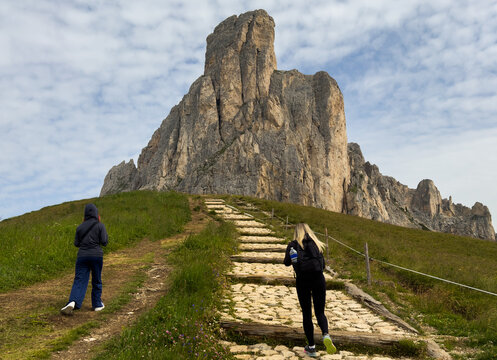 tourists walking in the dolomites at giau pass in summer italy