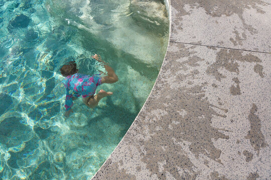 Young boy underwater in a backyard pool