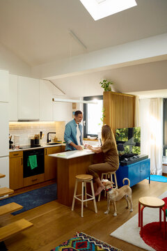 Two people chat in the kitchen