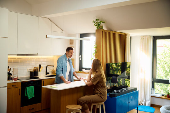 Two people talk in the kitchen