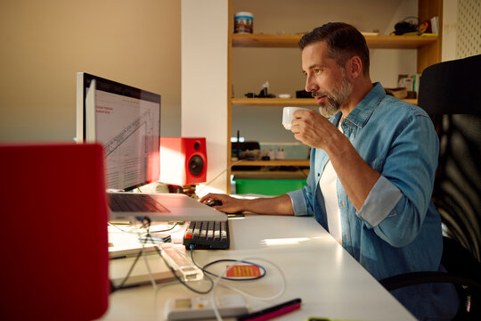 Focused man working on a project, drinking coffee