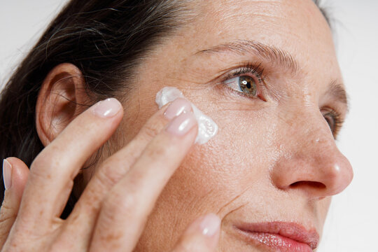 Woman applying moisturizer to her face