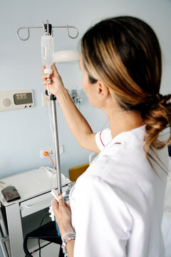 Nurse preparing iv drip in hospital room