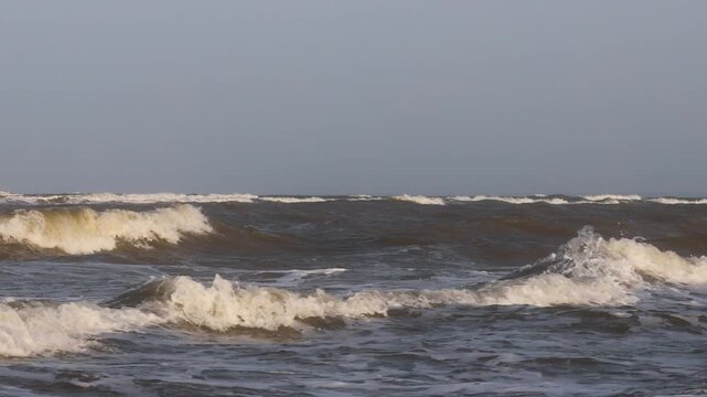 a large wave in the ocean, with sun shining down