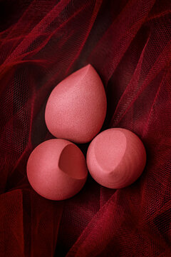 Red Makeup Sponges Placed on Draped Fabric