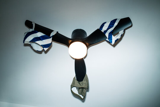 swimwear hanging from a ceiling fan to air dry indoors