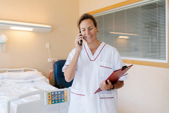 Nurse talking on mobile phone in hospital room
