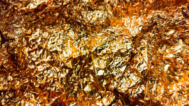 Gold metallic leaf or foil crumpled golden and silver texture background