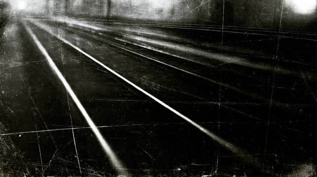 Long exposure photography showing light streaks on dark railway tracks with vintage film textures. Atmospheric backdrop for travel or conceptual themes.