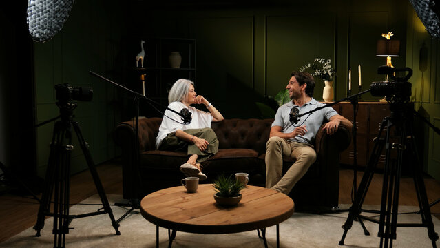 Two people engaging in a lively discussion with microphones and cameras during a live broadcast