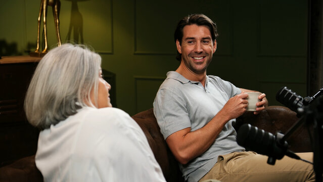 Man and woman having a conversation during a podcast recording session in a studio