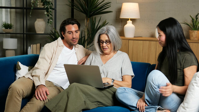 Multi generational family bonding while watching online content together on a laptop