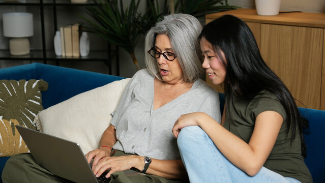Older woman and young multi ethnic girl connecting and learning with technology at home