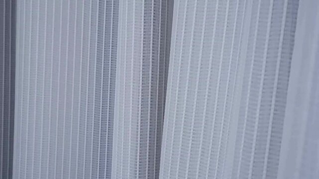 White sheer curtain blowing gently in the wind, peaceful morning concept, soft fabric texture background.
