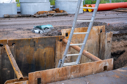 Metal ladder in rusty trench at construction site
