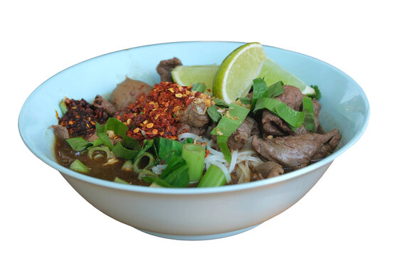 Freigestellte isolierte Thail&auml;ndische Fleisch Suppe mit Rindfleisch, Gem&uuml;se, Nudeln und scharfem Chili Gew&uuml;rz in einer Sch&uuml;ssel, der Saft von der sauren Limette perfektioniert den Geschmack