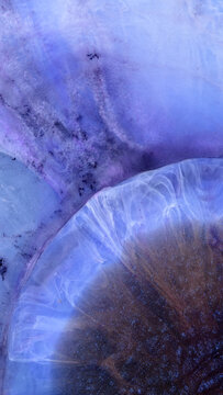 Mixing different colored alcohol inks with epoxy resin in close-up view