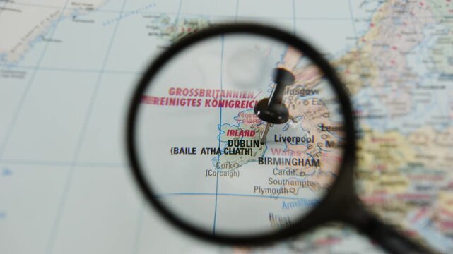 Magnifying glass shows location marked on a printed paper map