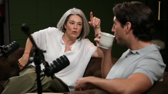 Female guest gesturing and speaking with a male host during a live radio show interview