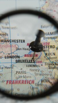 Magnifying glass reveals a location marked on a paper map