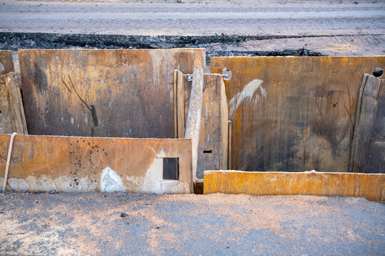 Rusty steel trench shoring panels at road construction site