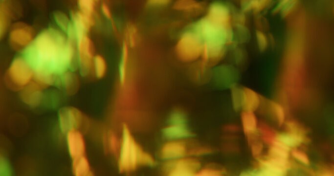 Blur kaleidoscope flare. Green light abstraction. Yellow pink orange colorful round optical gleam on luminous bokeh glisten background.