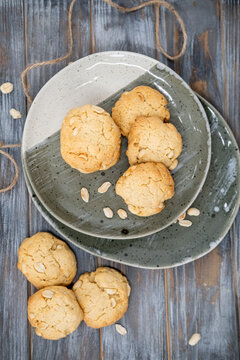 Cookies plate. Home pastry. Baked biscuits served stack on wooden table with scattered peanut ingredient. Tasty crunchy meal background.