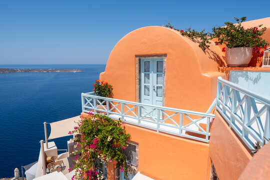 Santorini island, Greece. Colorful architecture with flowers in Oia town. Blue sea and the blue sky at sunny day.