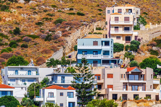 Beautiful view of hillside residential houses surrounded by rocky terrain and Mediterranean vegetation. Crete. Greece. 