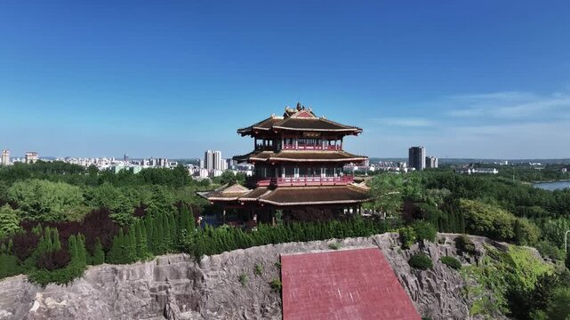 Ancient pagoda on mountain peak overlooking cityscape and lake scenery
