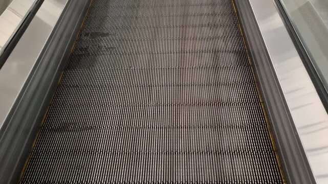 empty moving walkway escalator runs in a large hypermarket indoors. urban transport, shopping mall infrastructure, commercial building transit.