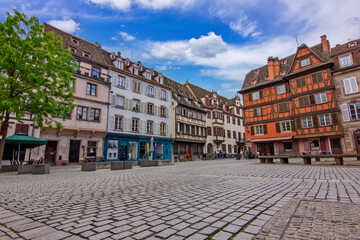 Obraz premium Historic Saint Stephen's Square in Strasbourg, France, surrounded by traditional half-timbered houses with colorful facades, wooden shutters and steep tiled roofs.